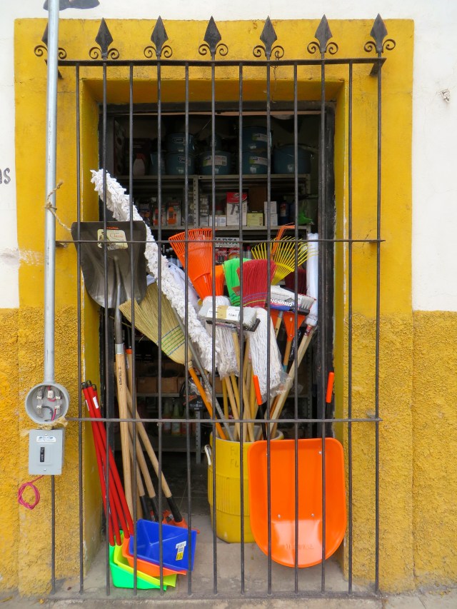 Brooms and mops in the window at Ferre-Carpintero, my neighborhood hardware store
